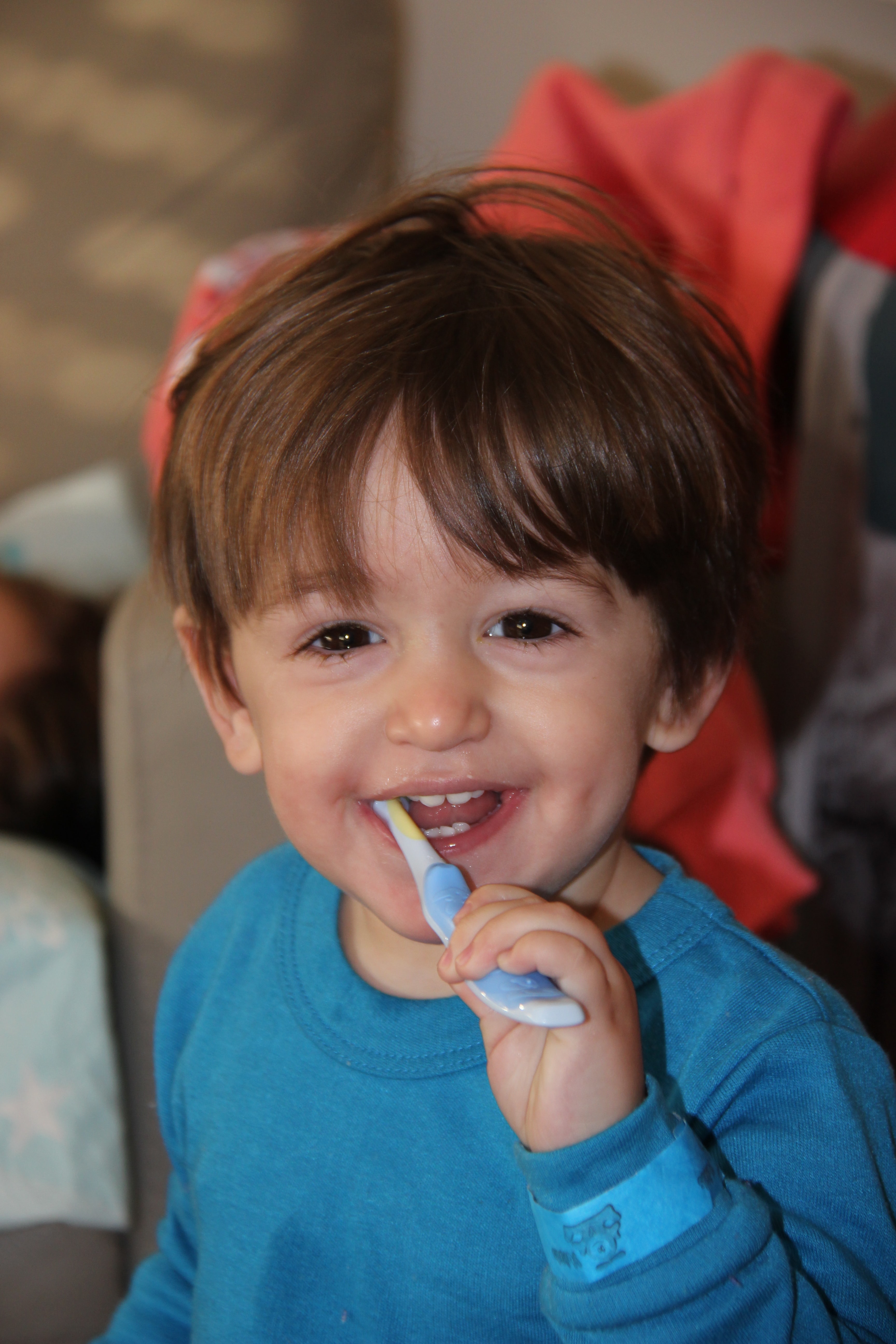 young boy brushing and smiling